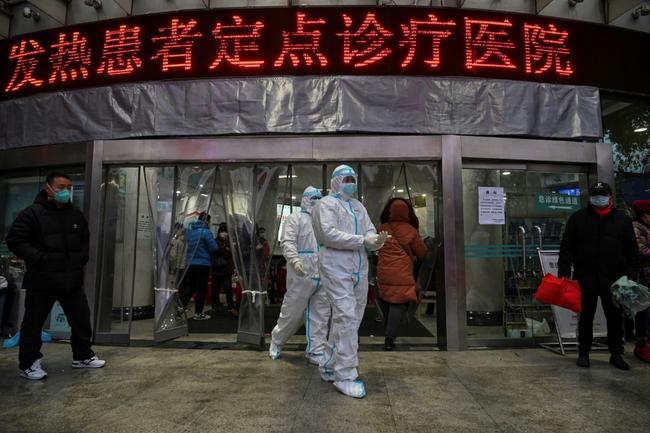 Medical staff members wear protective clothing outside the Wuhan Red Cross Hospital on January 25, 2020, two days after the city went into lockdown mode