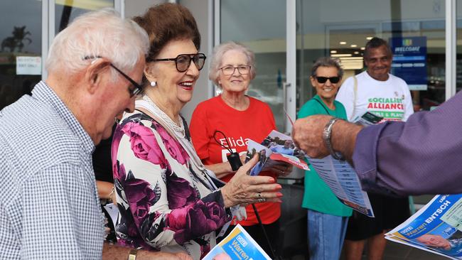 Barry Muir and Nora Farrelly accept a how to vote card from Member for Leichhardt Warren Entsch at the pre-polling booth at DFO Cairns, Westcourt. Picture: Brendan Radke