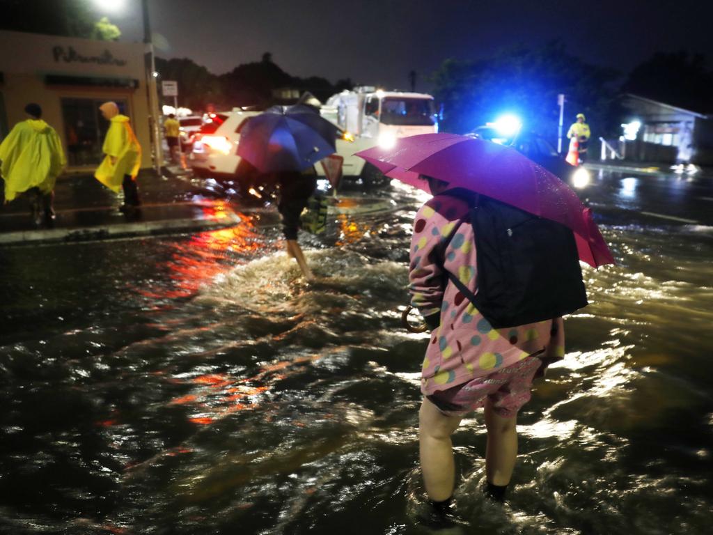 People trying to cross the road in Greenlane during torrential rain and severe flooding across Auckland and the North Island. Picture: Dean Purcell