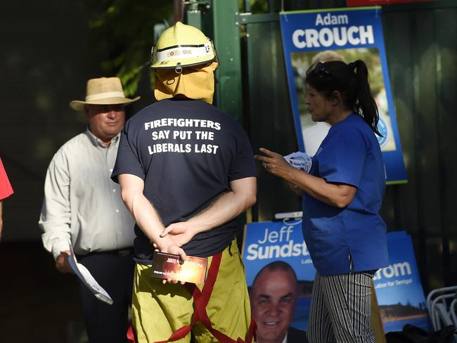 NSW Fire and Rescue fireman handing out what appears to be election material at Erina High School in breach of department protocol. Picture: Sue Graham