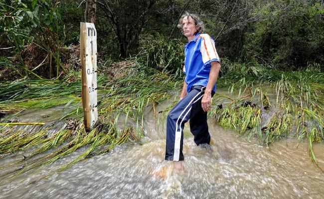 Glens Creek Rd resident Andrew Porelli in the flooded causeway which regularly blocks the road. . Picture: JOJO NEWBY