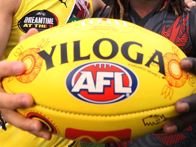 WARNING EMBARGO until Monday 15th MAY 2023. SEE PIC DESK Sherrin changing ball for Sir Doug Nicholls Round (Round 10) Indigenous AFL stars Daniel Rioli and Anthony McDonald-Tipungwuti, hold the SDNR Sherrin artwork designed by Tiwi woman Lulu Coombes.     Picture: David Caird