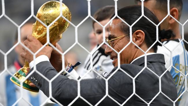 LUSAIL CITY, QATAR - DECEMBER 18: Nusret Goekce, nicknamed Salt Bae, admires the FIFA World Cup Qatar 2022 Winner's Trophy after the FIFA World Cup Qatar 2022 Final match between Argentina and France at Lusail Stadium on December 18, 2022 in Lusail City, Qatar. (Photo by Dan Mullan/Getty Images)