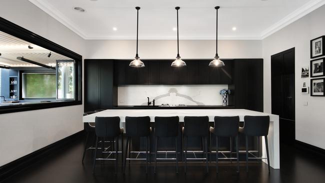 A servery window connects the main kitchen to a barbecue kitchen outside.