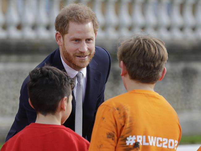 Britain's Prince Harry greets schoolchildren in the gardens at Buckingham Palace in London, Thursday, Jan. 16, 2020. Prince Harry, the Duke of Sussex will host the Rugby League World Cup 2021 draw at Buckingham Palace, prior to the draw, The Duke met with representatives from all 21 nations taking part in the tournament, as well as watching children from a local school play rugby league in the Buckingham Palace gardens. (AP Photo/Kirsty Wigglesworth)