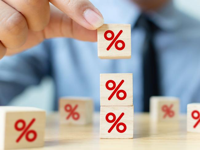 Interest rate financial and mortgage rates concept. Hand putting wood cube block increasing on top with icon percentage symbol upward direction