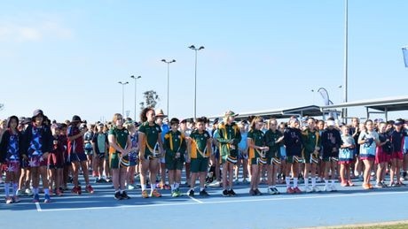 More than 1500 Queensland primary school netball players, officials, organisers and parents stood in silence this morning to commemorate the death of an 8-year-old Coomera Netball Club member who was one of two people killed in a head-on crash on the Bruce Highway near Childers on Friday. Picture: Sarah Steger