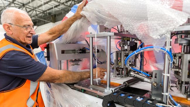 Joe Felice unpacks the new mask machine at Detmold as it arrives from China. Picture supplied