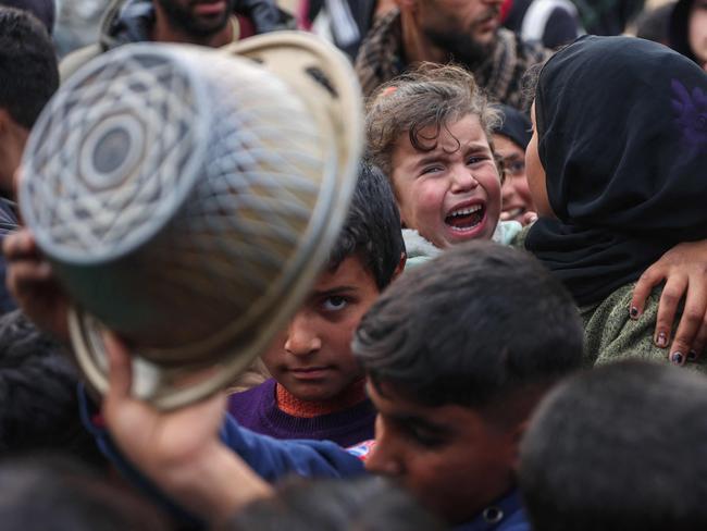 Displaced Palestinian children push into a queue to get a portion of cooked food from a charity kitchen in Beit Lahia in the northern Gaza Stri. Picture: AFP