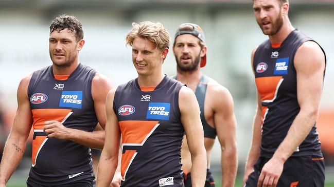 Lachie Whitfield, middle, suffered a nasty corkie against the Swans.