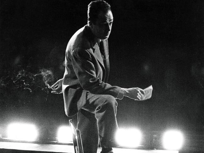 Albert Camus Directs His Play 'Les Possedes'. Les r?p?titions au th??tre Antoine de la pi?ce 'Les poss?d?s' d'Albert Camus, mise en sc?ne par l'auteur : attitude d'Albert CAMUS sur la sc?ne du th??tre, un pied sur une chaise et une cigarette ? la main, sous la lumi?re des projecteurs. (Photo by Jack Garofalo/Paris Match via Getty Images)