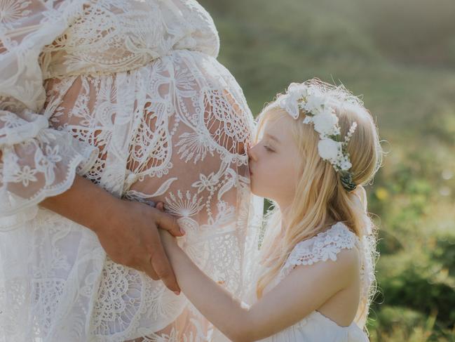 Asha, 6, kisses her mum Fiona Ellis-Jones’ pregnant belly.