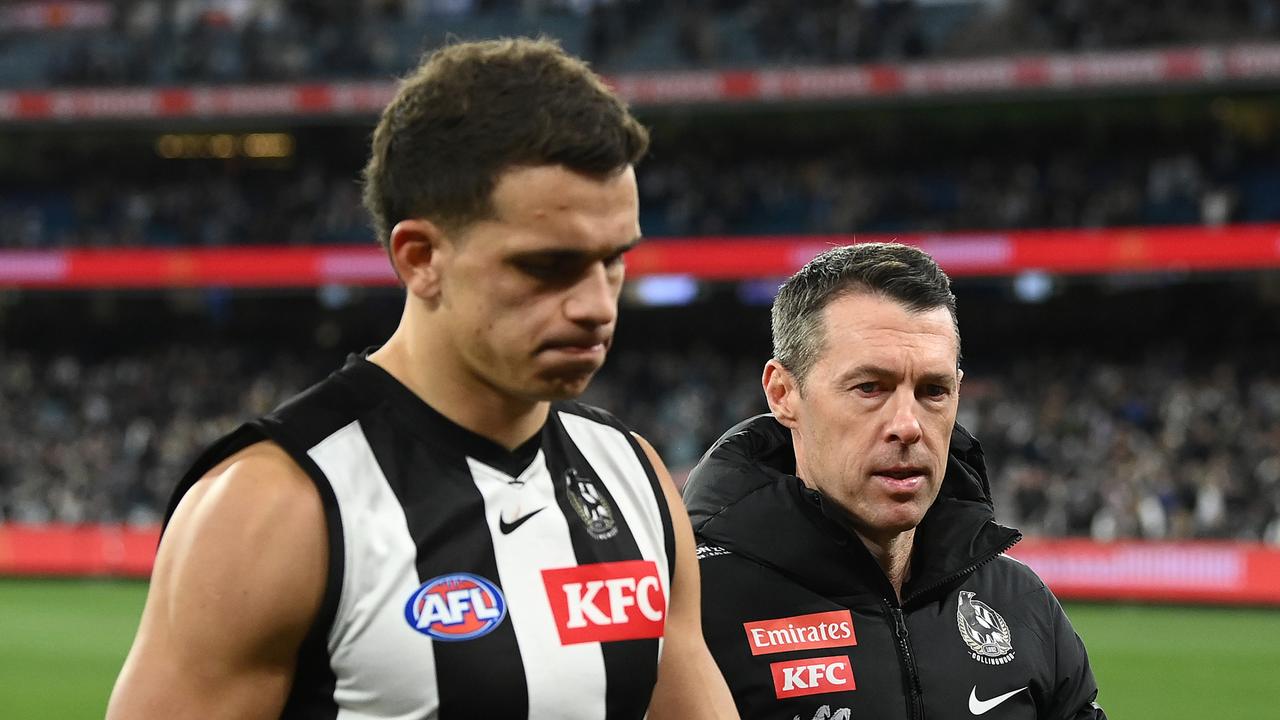 A dejected Ash Johnson trudges from the MCG alongside coach Craig McRae, who wanted his players to “act like winners” despite the narrow defeat. Picture: Getty Images