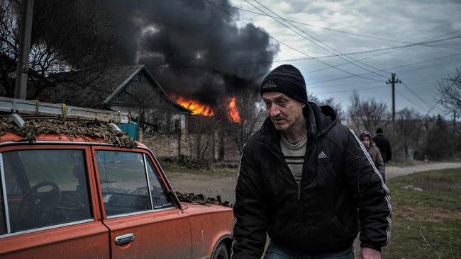 A local resident walks near a burning building after shelling in Kostyantynivka, Donetsk region. Picture: AFP