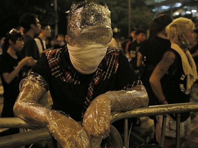 A protestor covers himself in gladwrap to avoid tear gas.