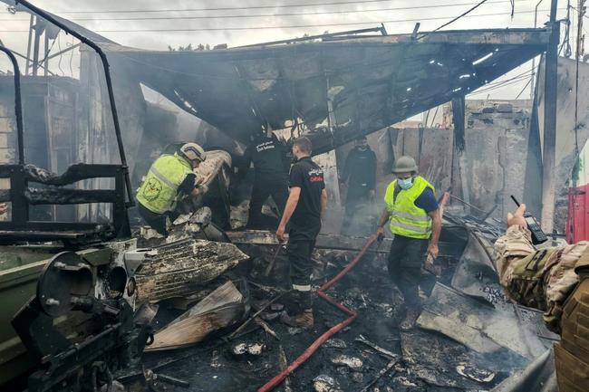 Rescuers douse the flames at the scene of an Israeli air strike that hit a Lebanese army post in southern Lebanon