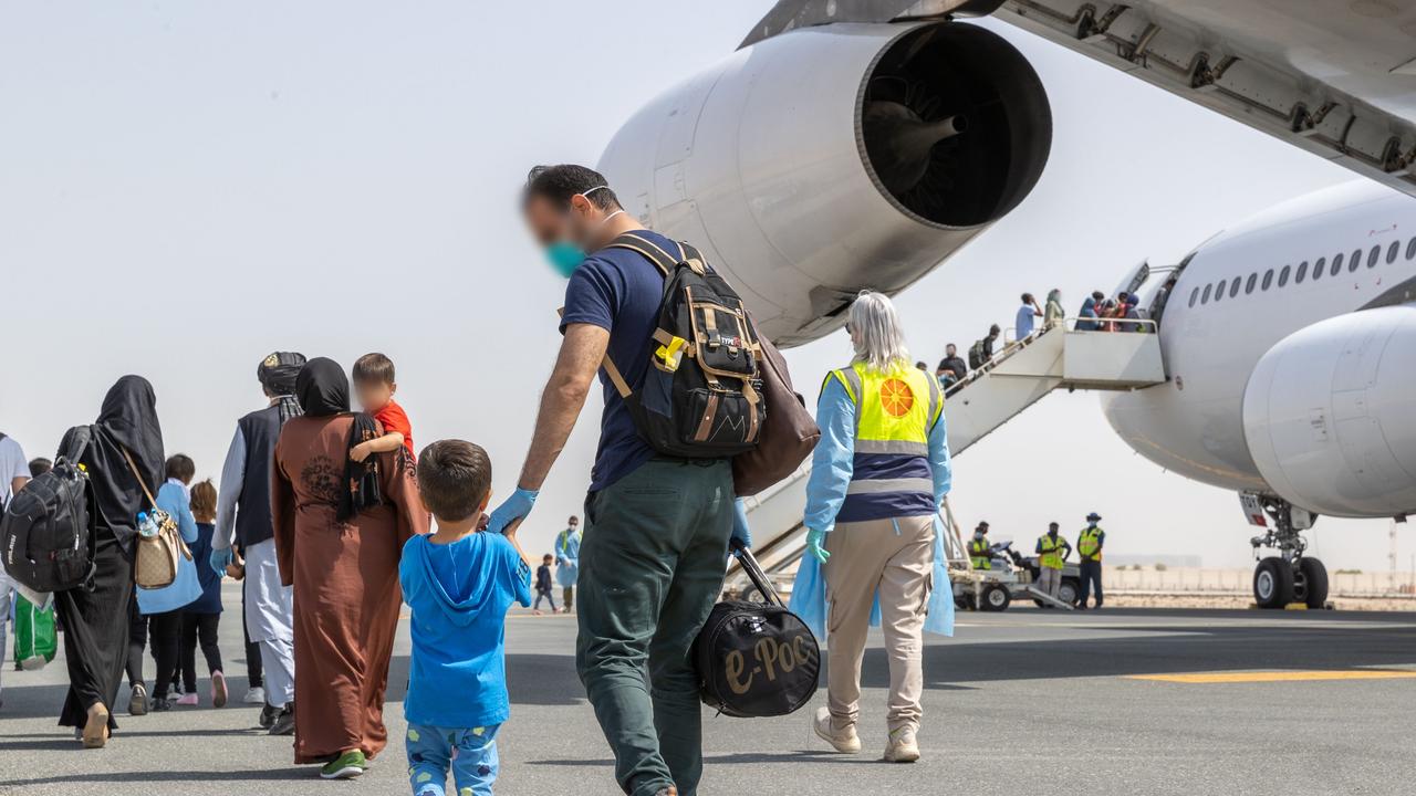 Afghanistan evacuees board a flight to Australia from the Australian Defence Force's main operating base in the Middle East region.