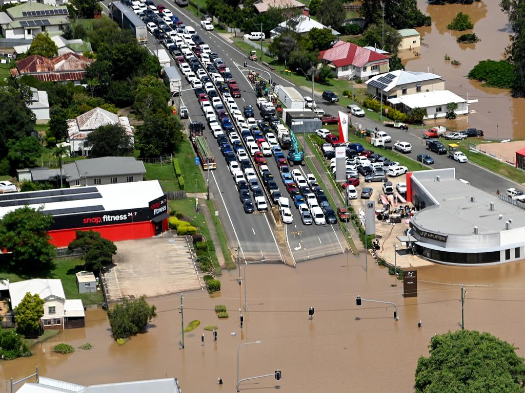 Vehicles are banked up as the Mary River cuts a street in Gympie yesterday. Picture: Bradley Kanaris/Getty Images