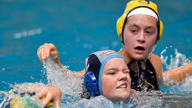 Hunter Hurricanes U14s player Kendra Burdack keeps her opponent at bay. Picture: John Gass.