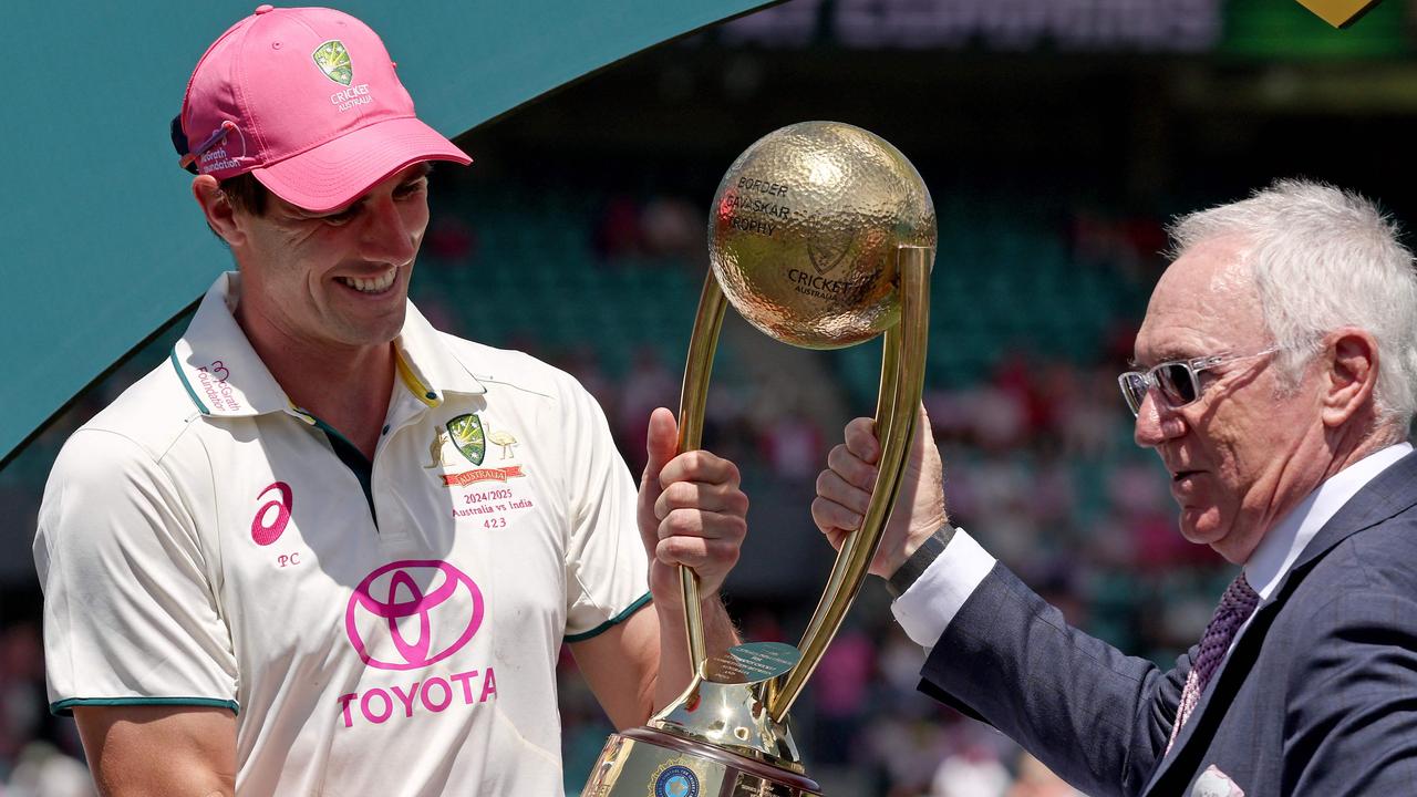 Australian captain Pat Cummins is handed the trophy by Allan Border. Photo by DAVID GRAY / AFP