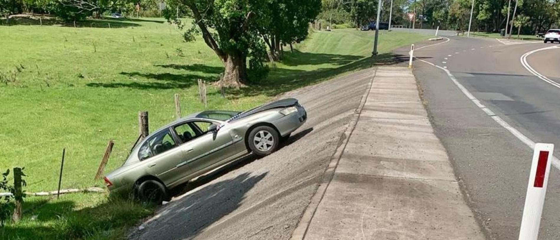 The car on Power Road has somehow gone over the lip of the concrete culvert backwards.