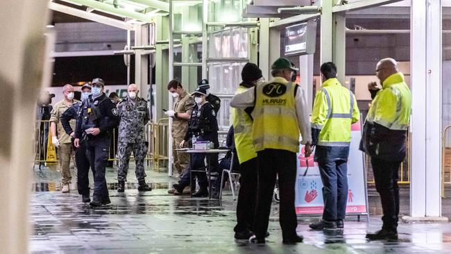 Army, Navy, Police, Security and coach personnel await passengers at Sydney International Airport. Picture: Monique Harmer