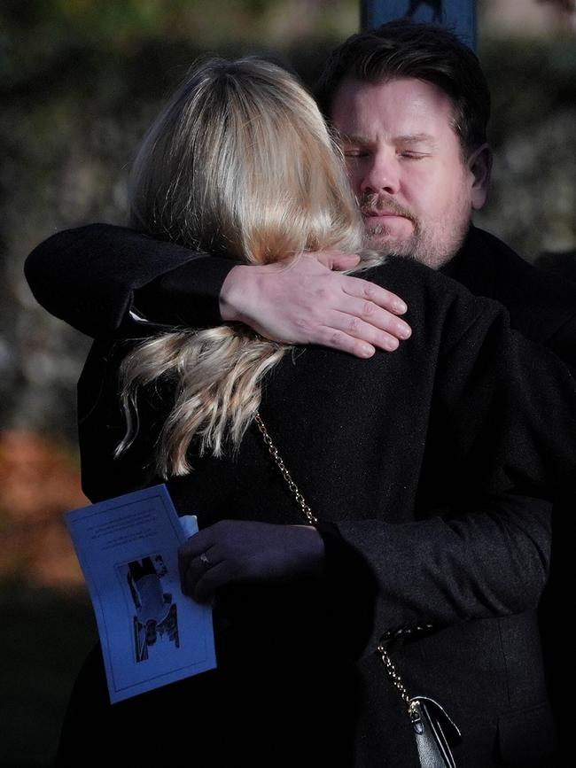 James Corden hugs another guest after the funeral service. Picture: PA Images via Getty Images