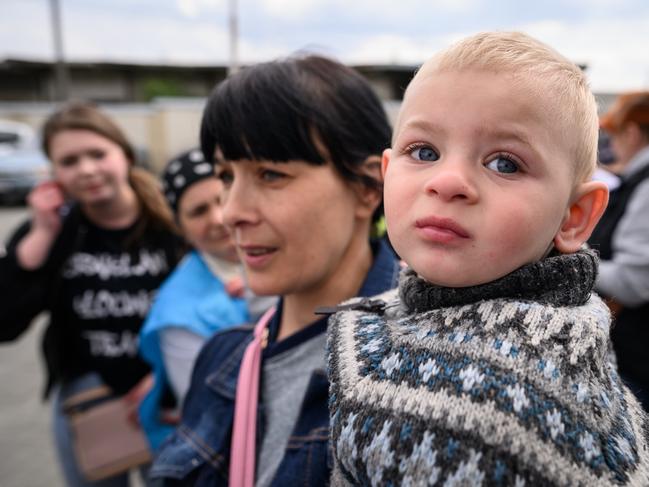 LVIV, UKRAINE - MAY 03: Alexey Dulai is held by his mother Natalia Dulai as they wait to board a coach destined for Przemysl in Poland, carrying refugees from regions of Southern and Eastern Ukraine, including Mairupol, on May 03, 2022 in Lviv, Ukraine. Lviv has served as a stopover and shelter for the millions of Ukrainians fleeing the Russian invasion, either to the safety of nearby countries or the relative security of western Ukraine. (Photo by Leon Neal/Getty Images)