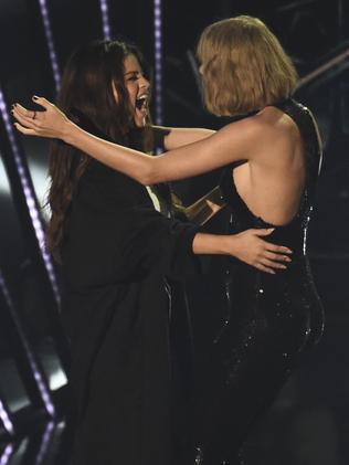 Taylor Swift, right, accepts the award for album of the year from bestie Selena Gomez. Picture: Chris Pizzello / Invision / AP