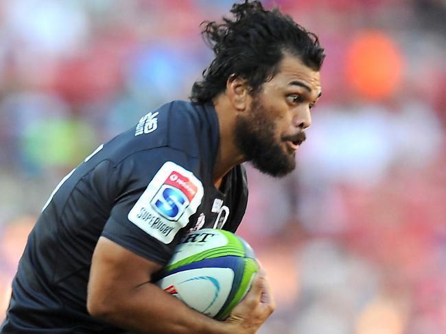 Karmichael Hunt (C) of the Reds tries to avoid a tackle from Lions Rohan Janse van Rensburg (L) during the Super XV rugby union match between The Lions and the Queensland Reds at Ellis Park Stadium on March 18, 2017 in Johannesburg, South Africa. / AFP PHOTO / STRINGER