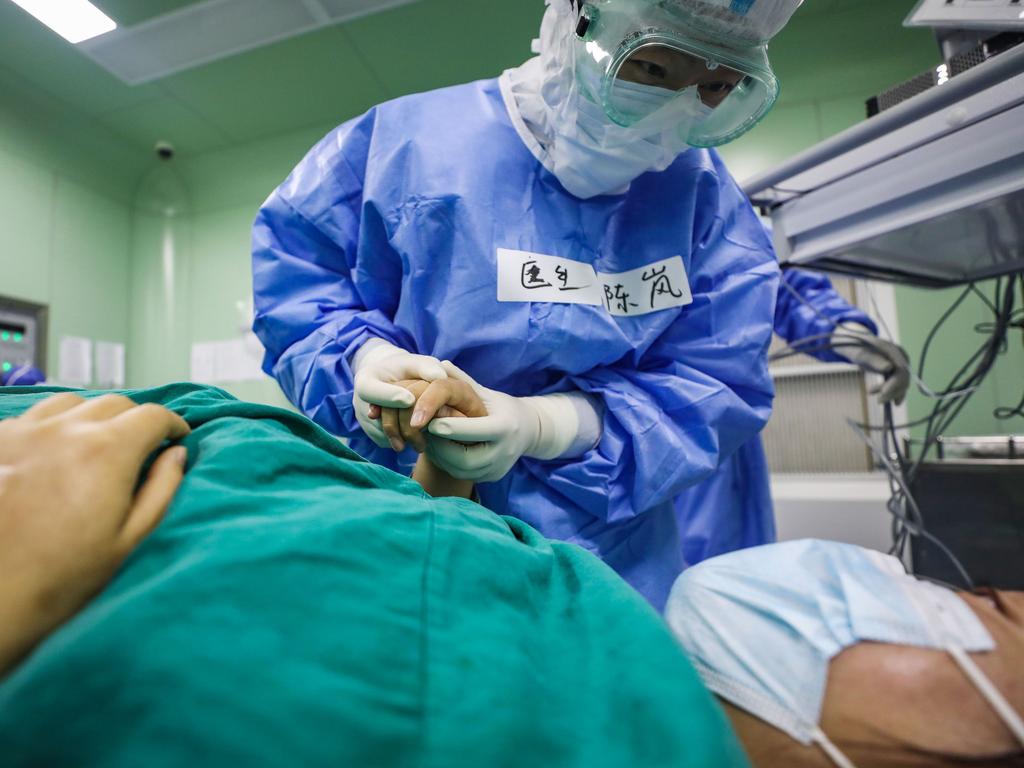 A doctor comforts a pregnant woman, infected with coronavirus, at a hospital in Wuhan in China. Picture: STR/AFP