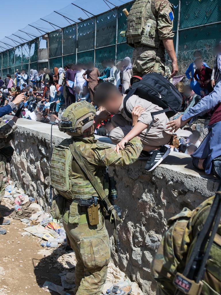 Members of the 1st Battalion, Royal Australian Regiment ready combat team assist the Department of Foreign Affairs and Trade with locating Afghan Australian visa holders attempting to enter the congested Abbey Gate at Hamid Karzai International Airport. *** Local Caption *** The Ready Combat Team including members of the 1st Battalion, the Royal Australian Regiment, have been working with Australian Government officials from the Department of Foreign Affairs and Trade, Department of Home Affairs and Australian Border Force to identify, collect and assist Australian nationals and approved foreign nationals enter Hamid Karzai International Airport at Abbey Gate.