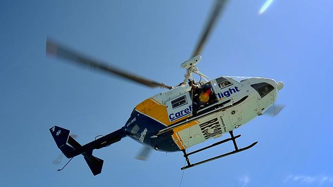 Care Flight simulating rescue drills from 'First Class' boat to their helicopter in Darwin Harbour >>> Faron Ryan, Care flight operations officer gives the thumbs up for the winching of the rescue basket with dummy, Ado on board.