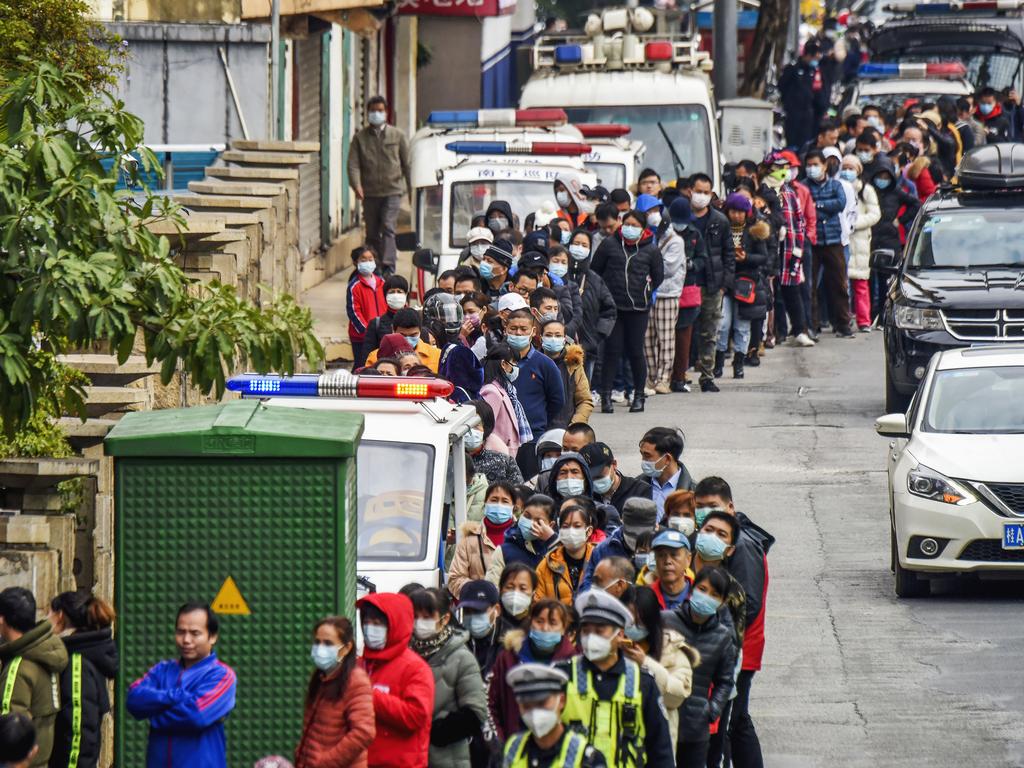 Lining up in China, where factories have been taken over by the government. Picture: Chinatopix via AP, File.