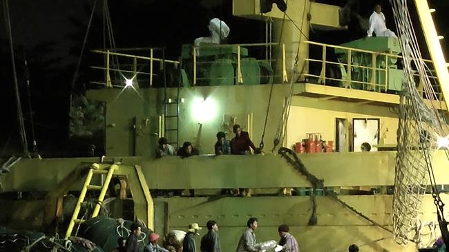 Workers from Myanmar load fish onto a Thai-flagged cargo ship in Benjina, Indonesia. An intricate web of connections separates the fish we eat from the men who catch it, and obscures a brutal truth: Your seafood may come from slaves.