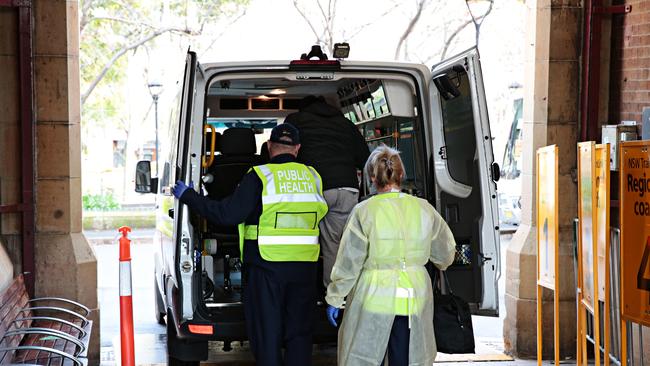 A man is taken away for COVID-19 testing after travelling on the XPT from Melbourne arrive at Central station in Sydney on Saturday. PICTURE: Adam Yip