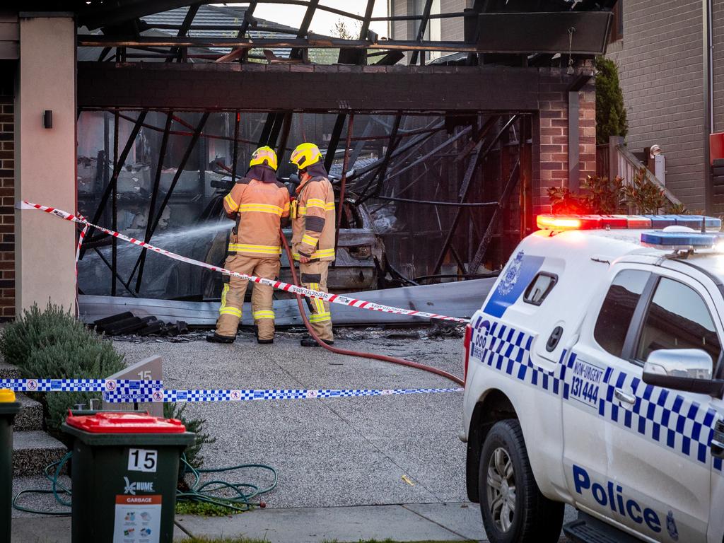 Fire crews at the Greenvale home the morning after a car was driven into the garage and set alight. Picture: Jake Nowakowski