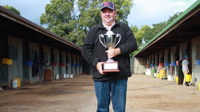 Toowoomba horse trainer Kevin Kemp holds the Weetwood Handicap trophy at his stables. Kemp won the 2014 Weetwood with Typhoon Red and had Kempelly run second. That achievement saw Kemp take out The Chronicle-Clear Mountain Fairview Trainer of the Month for April.