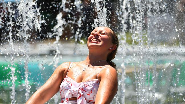 A woman gets some relief from the heat in a fountain in Garden Square. Photo: Quinn Rooney/Getty Images