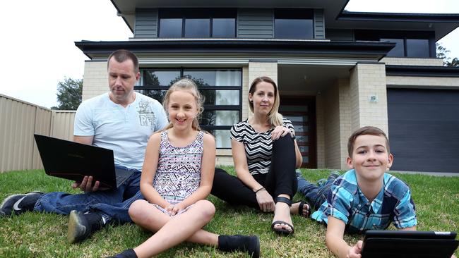 10/10/2017: Benjamin and Rachel Stewart with their children Olivia, 9, and Daniel, 11, at home in Nerara, Central Coast, NSW. Their Telstra internet speeds have plummeted over the last two weeks, probably due to school holidays.Pic by James Croucher