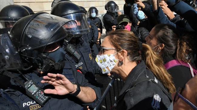 Demonstrators in front of Catalan regional police in Barcelona to protest against the new restrictions imposed by the regional government on bars and restaurants to fight against COVID-19 disease. Picture: AFP