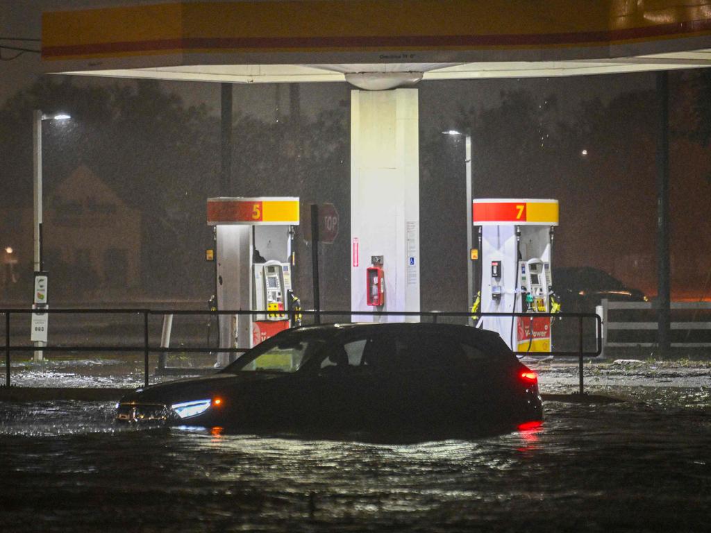 A car is stranded on a water-flooded street after Hurricane Milton made landfall.