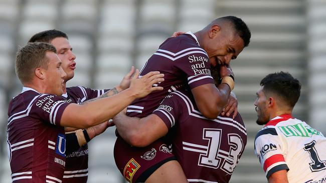 Teammates mob Corey Waddell (#13) after he scored the opening try. Picture: Getty