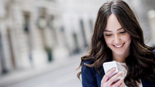 Business woman texting on her phone – outdoors