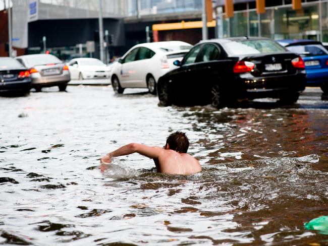 A man swims along Elizabeth St in 2010. Picture: HWT Library.