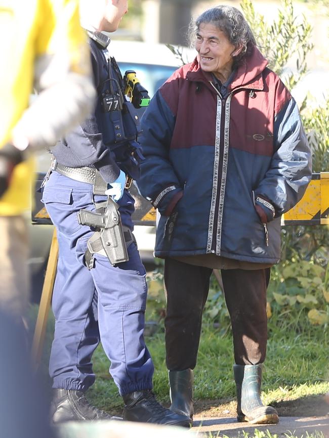 Mary Bobolas speaks to a police officer outside her house during a council-ordered clean-up in 2015. Picture: John Grainger