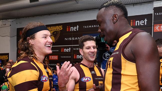 Hawthorn recruits Jack Ginnivan (left) and Mabior Chol (right) celebrate with veteran Luke Breust after their demolition of Collingwood on Saturday. Picture: Graham Denholm / Getty Images