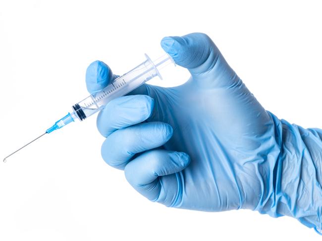 Hand with blue glove holding a syringe blue solute white background