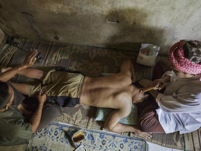 An Islamic faith healer chants as his assistant slaps the leg of a man at the Pengobatan Alternaif Nurul Azha centre in West Java. Picture: Andrea Star Reese/Human Rights Watch.