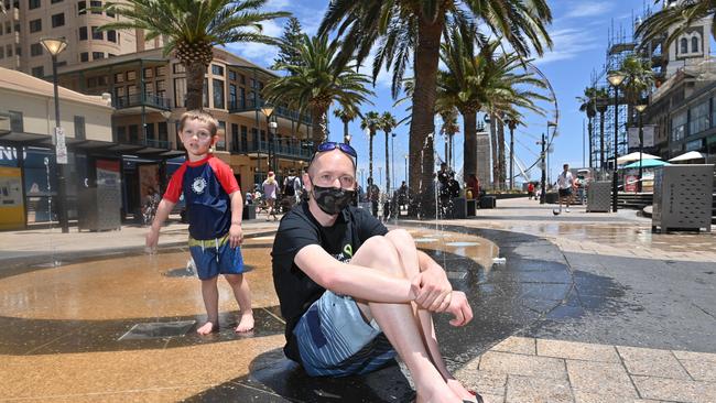 Cebastian and dad Jamie Young, 28 keep cool at Glenelg. Picture: Keryn Stevens